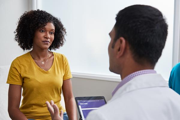 Mujer conversando con un médico en un centro sanitario