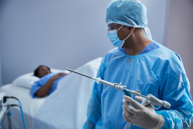 Técnico de laboratorio pulsando el botón de la pantalla de un sistema médico en un laboratorio