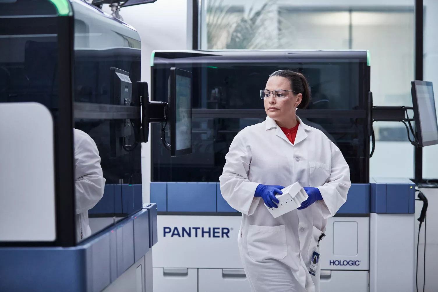 Imagen de un técnico de laboratorio caminando por un laboratorio.