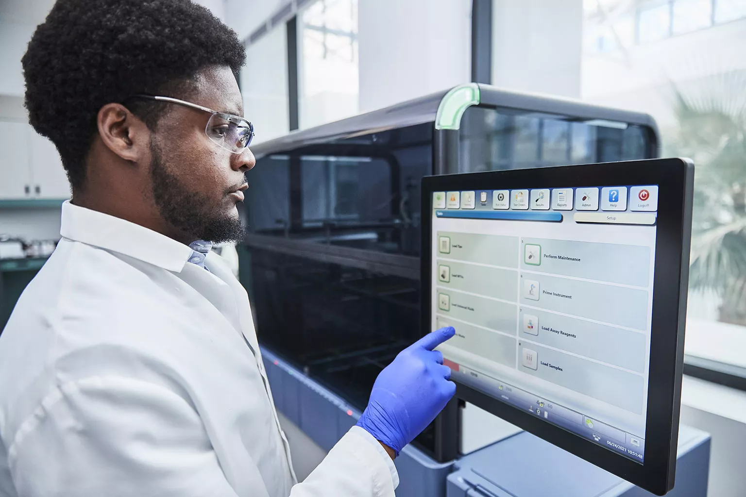 Médico tocando la pantalla de un sistema Panther en un laboratorio.