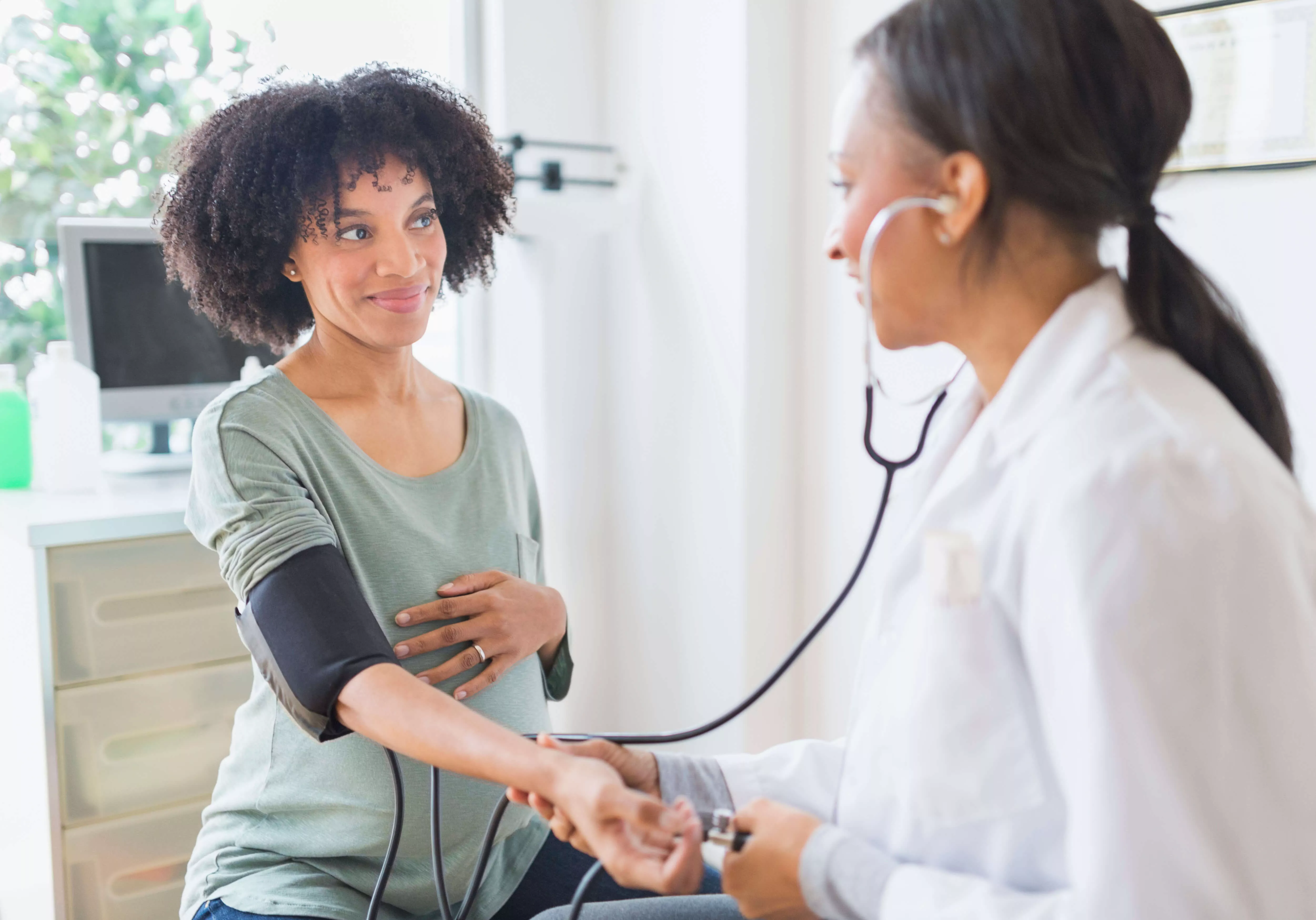 Doctora que utiliza el estetoscopio en el brazo de una mujer.