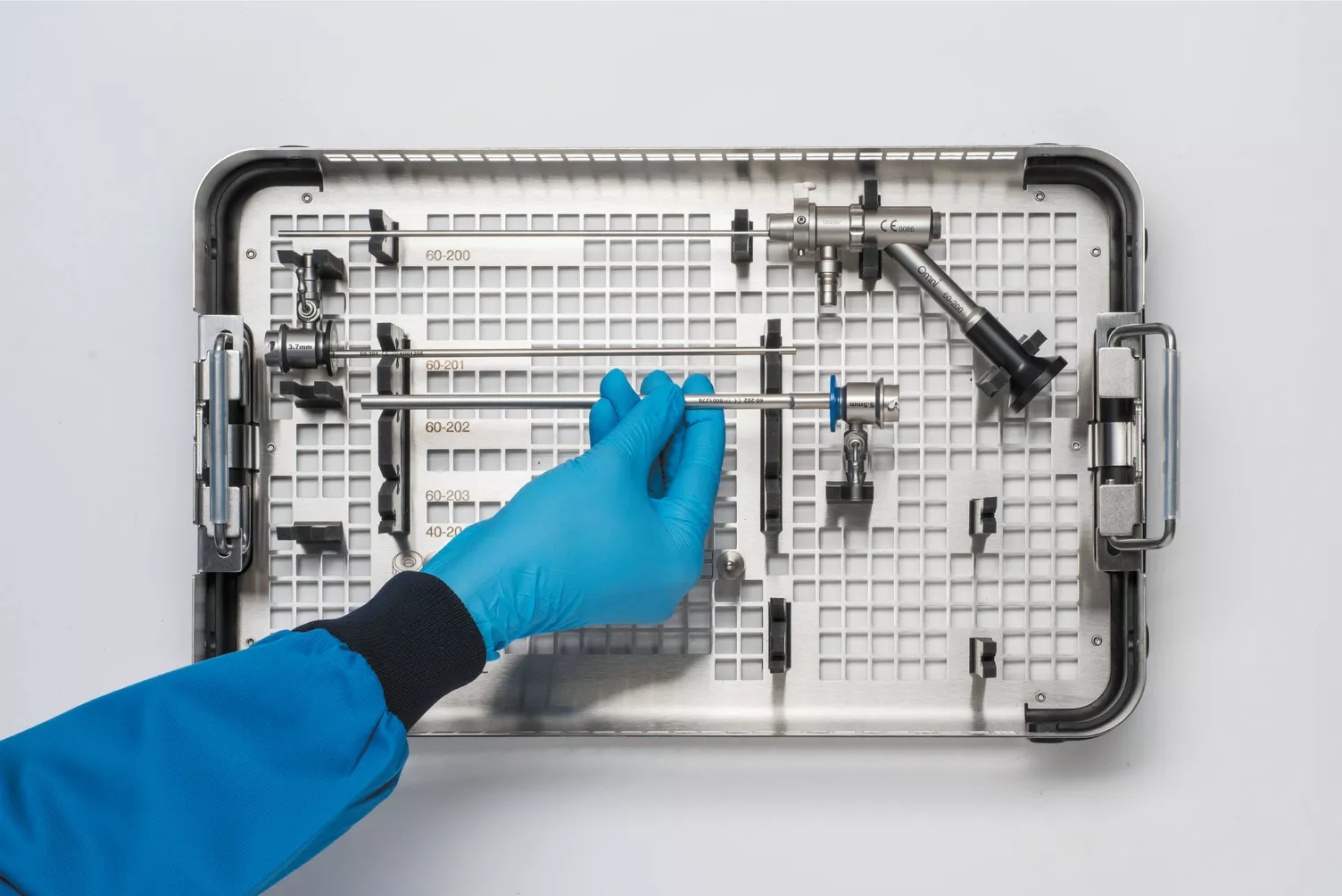 Mano con guante trabajando con la bandeja médica sobre una mesa.