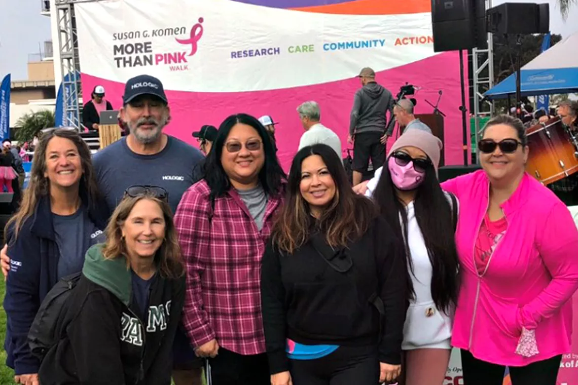 Fotografía de grupo de hombres y mujeres sonrientes durante la marcha solidaria Race for the Cure de Susan G. Komen