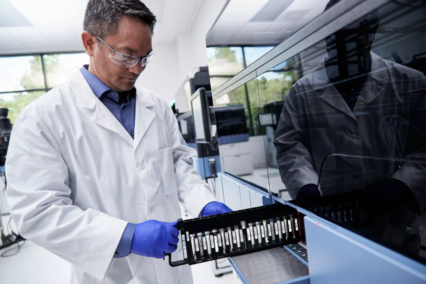 Técnico de laboratorio cargando tubos de ensayo en un equipo