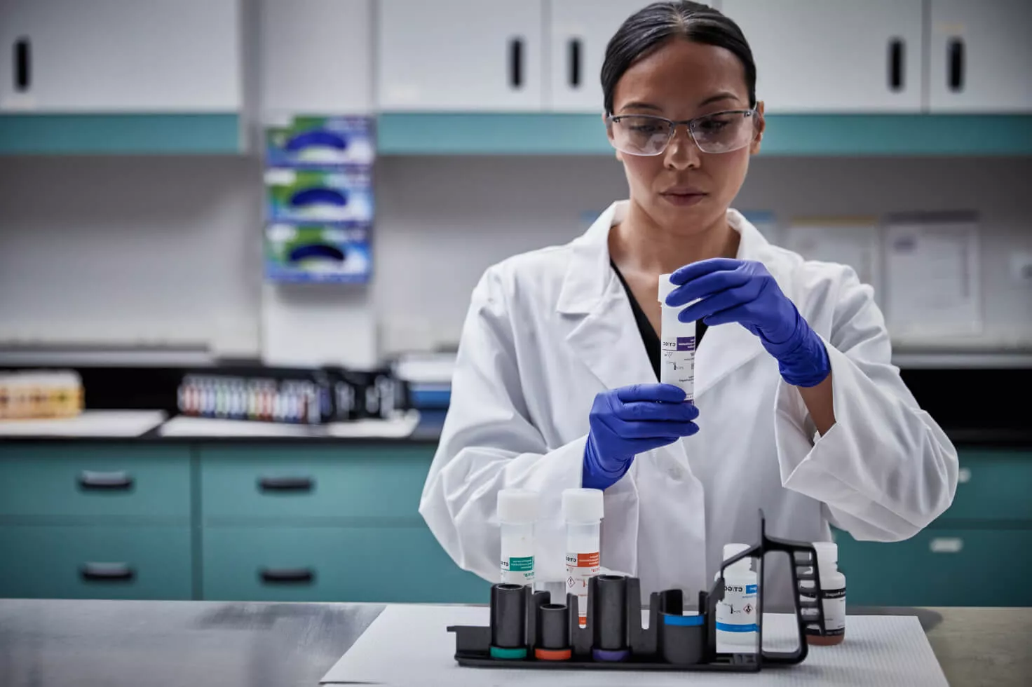 Técnico de laboratorio sostiene un kit de toma de muestras de frotis en un laboratorio